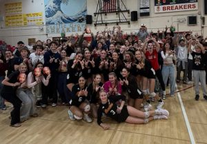 Varsity players and spectators celebrating after PG's three set sweep on Carmel